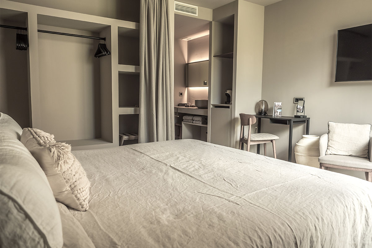 Moderne Pequeña Suite im Barefoot Hotel auf Mallorca mit gemütlichem Bett, Schreibtisch und entspannter Atmosphäre.