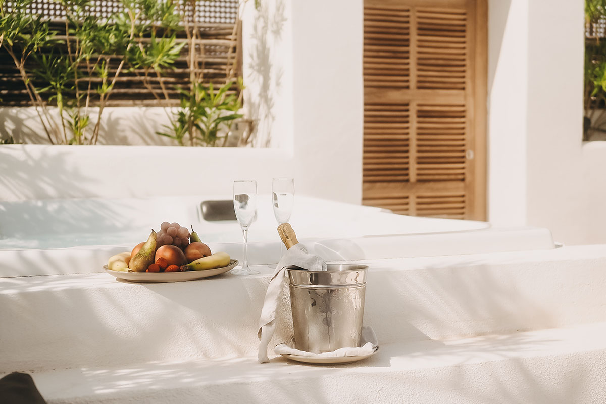 Privater Whirlpool in der Pequeña Suite des Barefoot Hotels Mallorca mit Champagner, Gläsern und frischen Früchten.