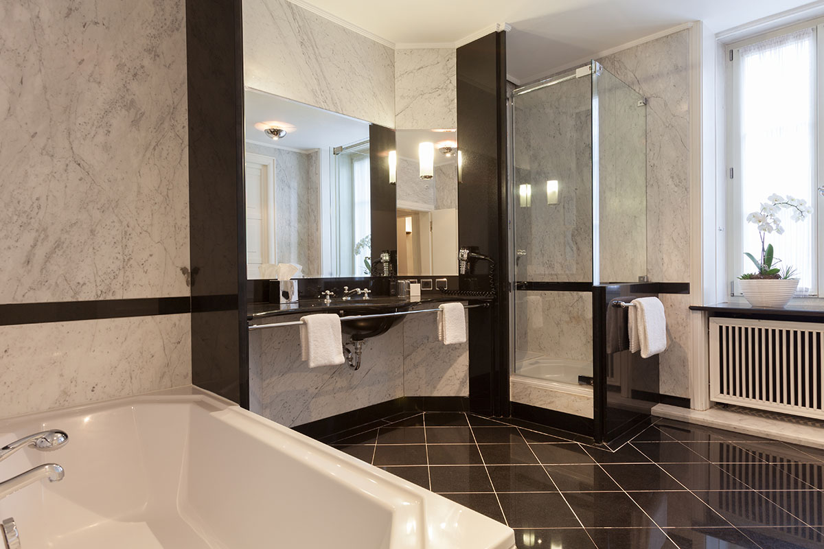 Hochwertiges Badezimmer der Thomas-Mann-Suite im Hotel Elephant Weimar mit luxuriöser Dusche, Marmor-Design und viel Tageslicht.