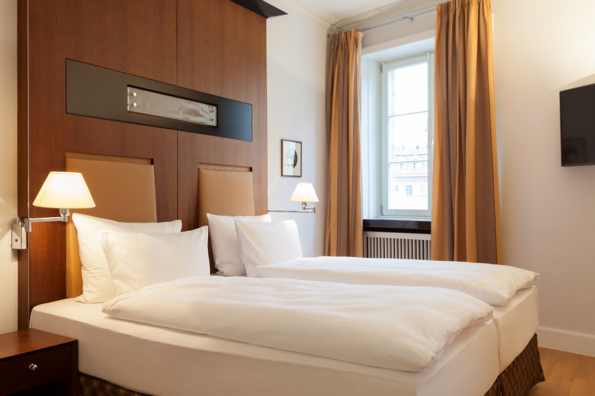 Erholsames Ambiente im Schlafbereich mit hochwertigem Bett in der Thomas Mann Suite im Hotel Elephant Weimar.