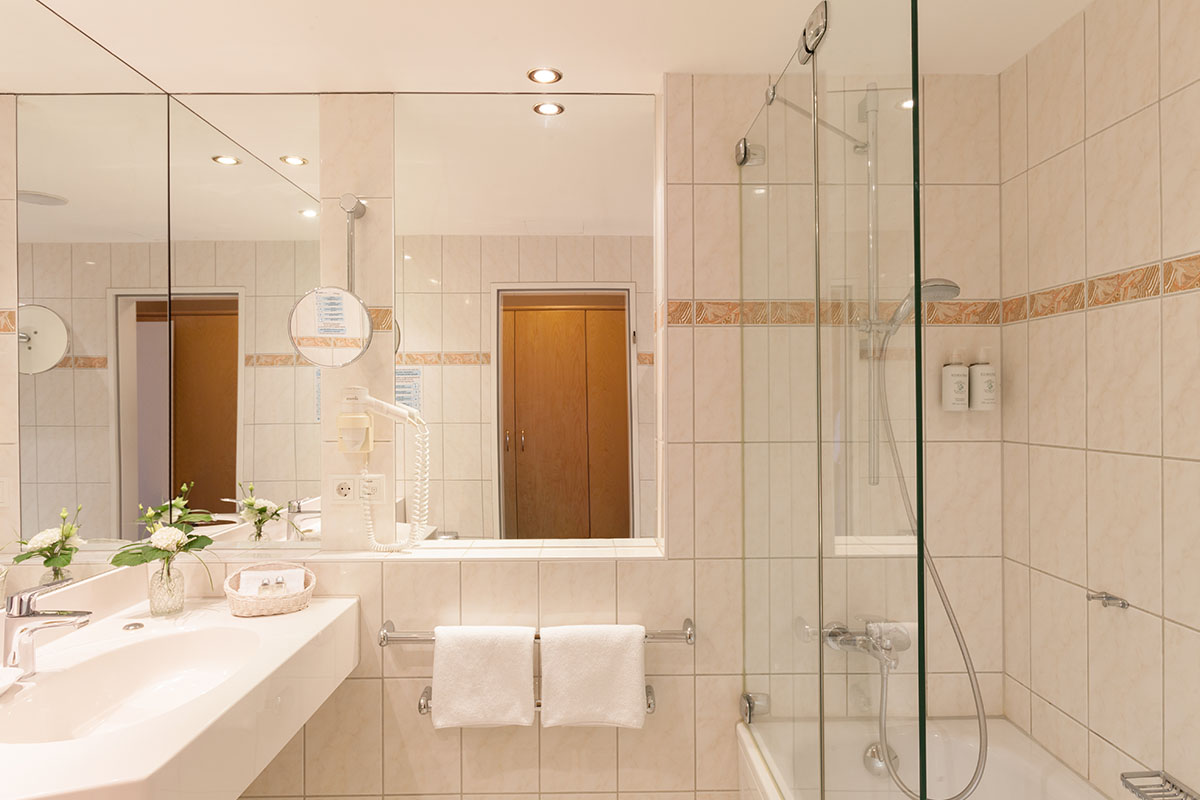 Spacious bathroom with mirror wall, shower and high-quality care products in the Comfort double room at the Hotel Kaiserhof.