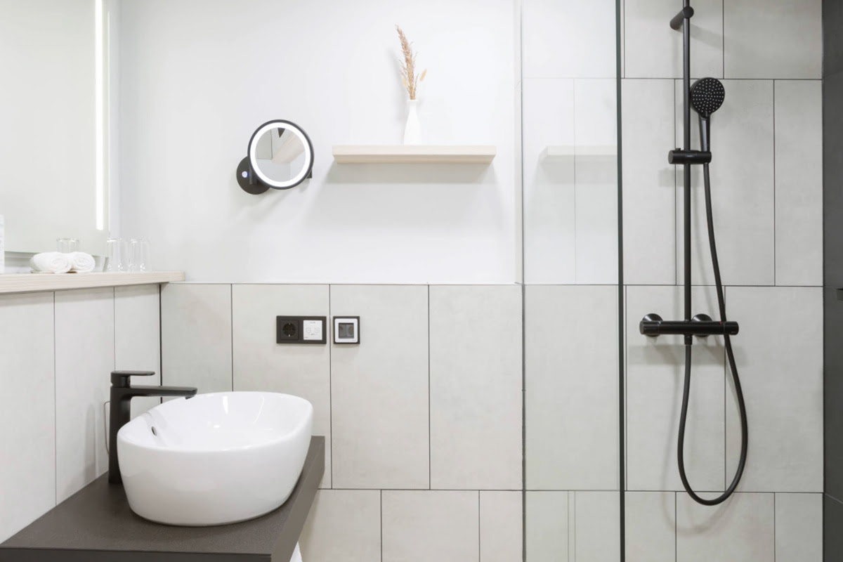 Modern bathroom with large shower and sleek design in the deluxe double room at the Hotel Kaiserhof Heringsdorf.