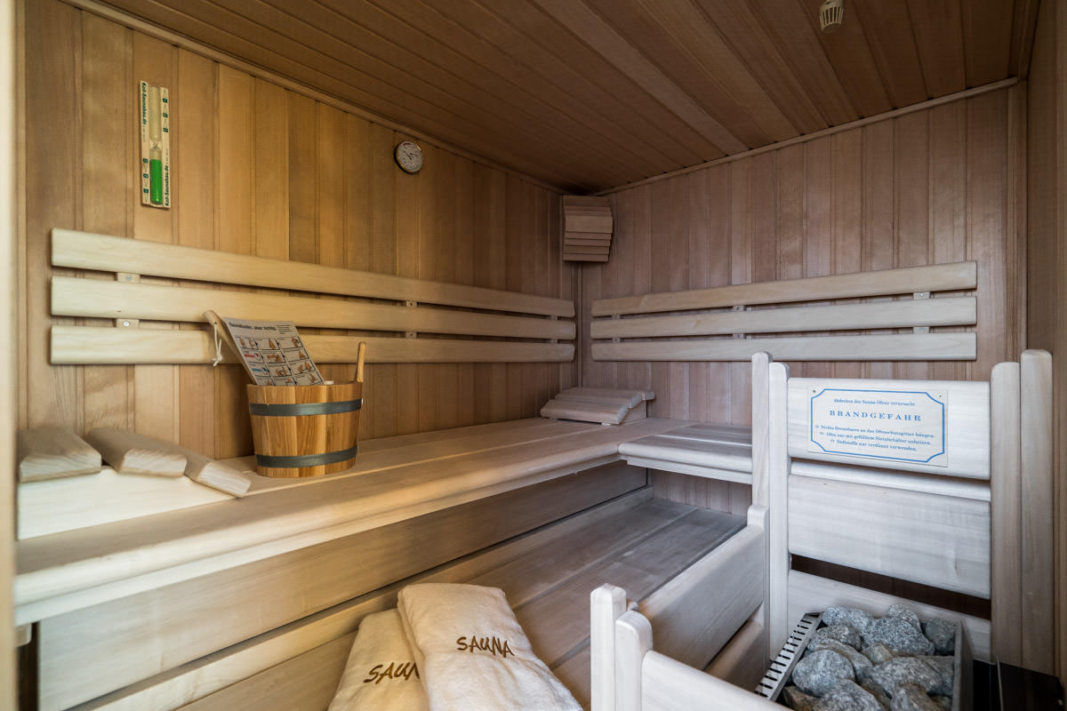 Wooden sauna with benches and towels, ideal for relaxing in the Seewind vacation home at the Hotel Künstlerquartier Seezeichen.