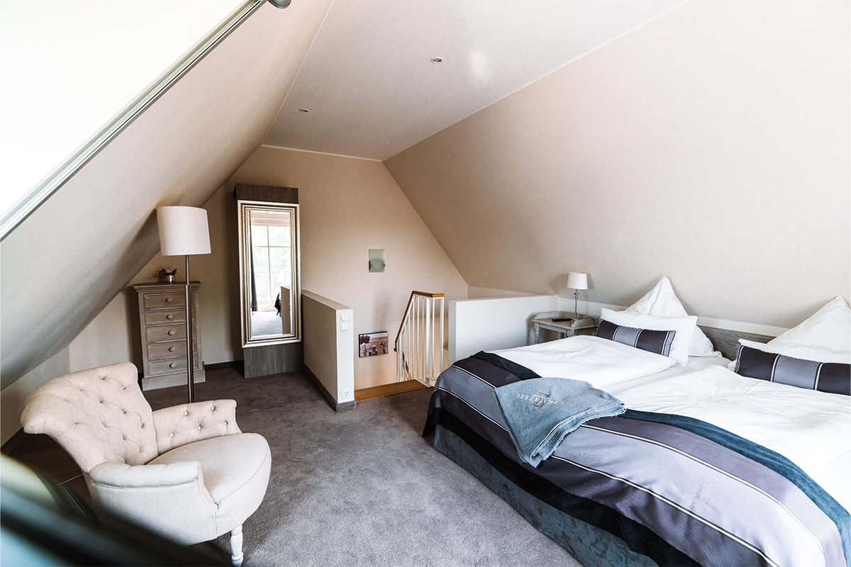 Comfortable double bed in the spacious bedroom of the Seeigel vacation apartment in the Hotel Künstlerquartier Seezeichen.