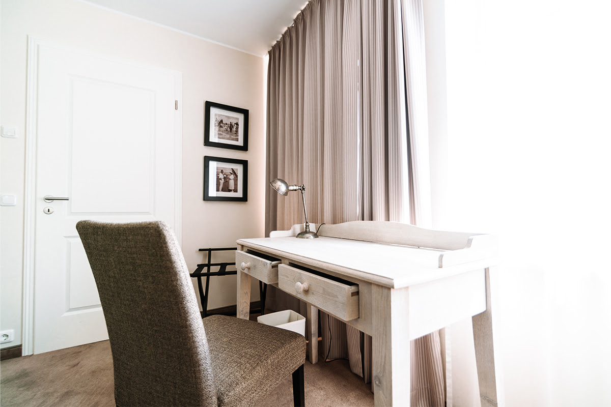 Stylish desk with comfortable chair in the bright room of the Stranddistel vacation apartment in the Hotel Künstlerquartier Seezeichen.