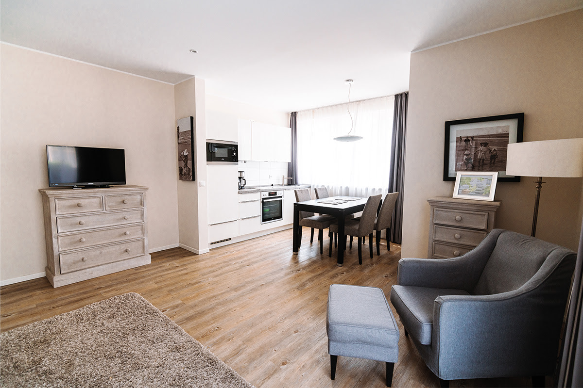 Modern vacation apartment Strandmuschel with dining area and open kitchen in the Hotel Künstlerquartier Seezeichen.