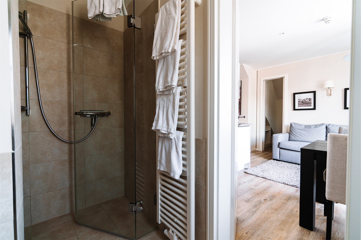 Elegant glass shower with soft towels in the Strandnixe vacation apartment in the Hotel Künstlerquartier Seezeichen.