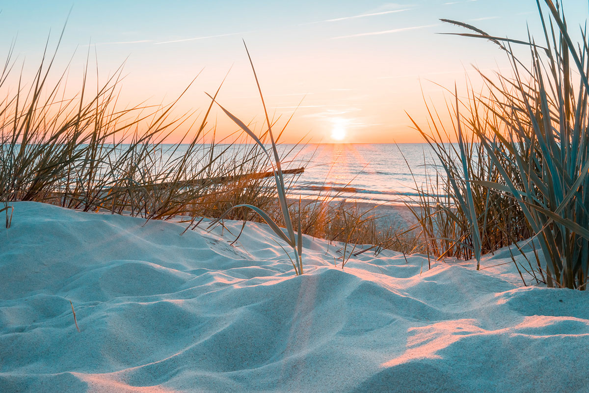 Sonnenuntergang am Strand mit Dünen und Meerblick und ruhiger Atmosphäre am Hotel Künstlerquartier Seezeichen.