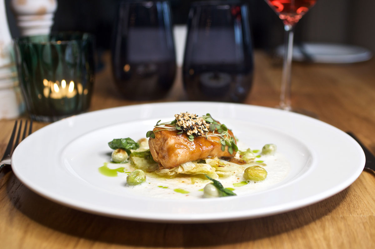 Noble fish dish with crispy crust, vegetable garnish and fine sauce in the restaurant of the Vju Hotel.