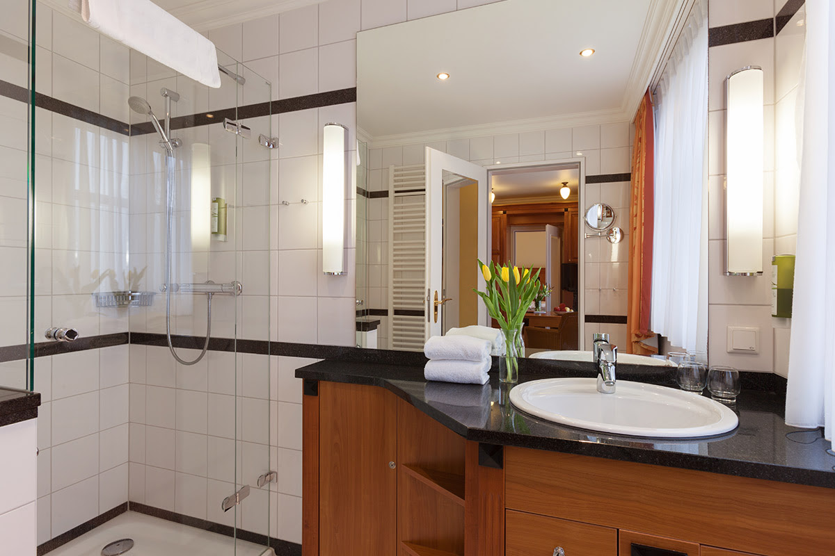 Modern bathroom with spacious shower, stylish washbasin and large mirror in the 2-room room at the Vju Hotel on Rügen.