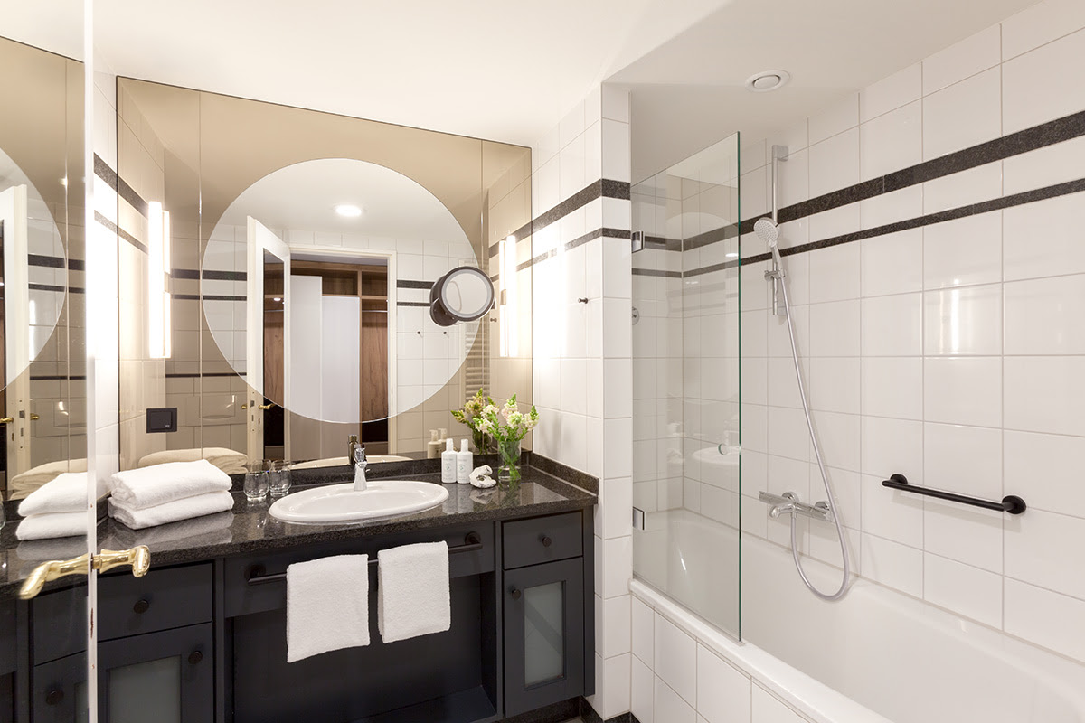 Helles Hotelbad mit moderner Badewanne und Dusche im Doppelzimmer mit Balkon des Vju Hotels auf Rügen.